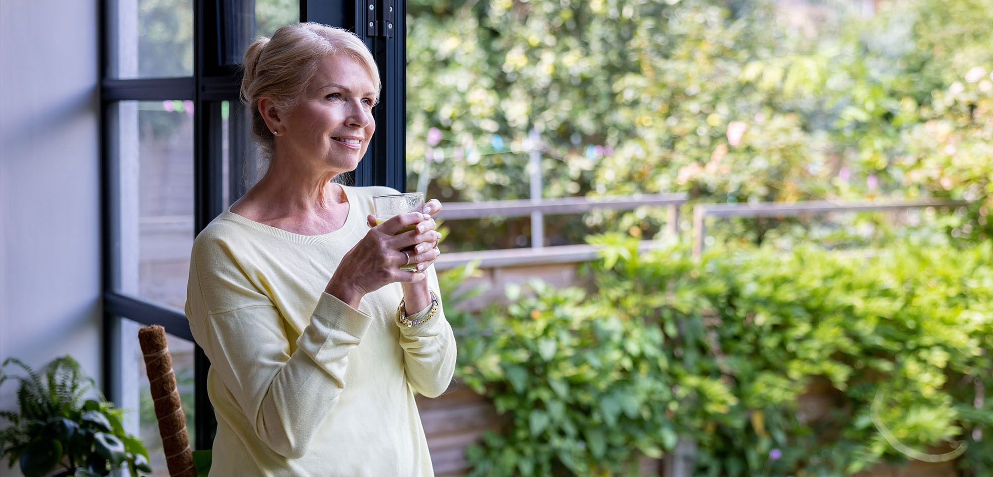 Happy woman at home drinking a juice in the morning